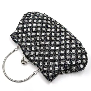 Detailed view of the beaded evening clutch bag with metallic handle and sparkly fish-scale sequins.