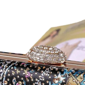 Detailed close-up of a luxury rhinestone evening clutch with colorful printed satin and gold clasp.