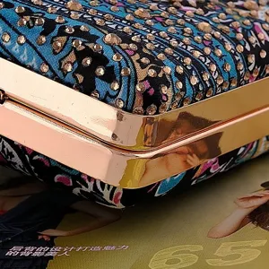 Detailed close-up view of rhinestone evening clutch bag with rose gold metal frame.