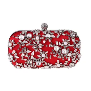 Close-up detail of the red satin rhinestone evening clutch bag with sparkling crystal stones.