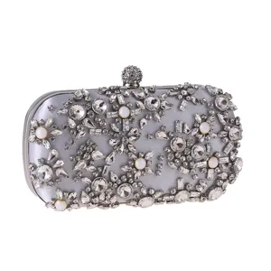 Detailed view of luxury rhinestone evening clutch bag with sparkling crystals and pearls for party.