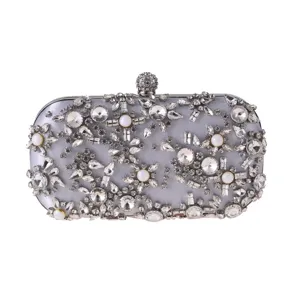 Detail view of silver satin evening clutch bag decorated with shiny rhinestones and pearls.