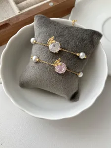 Elegant gold plated bracelet with sparkling zircon, pearl, and butterfly charm for women.