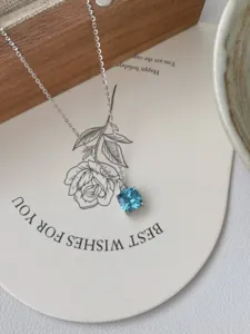 Gros plan détail du collier pendentif en argent sterling avec zircone bleue carrée.
