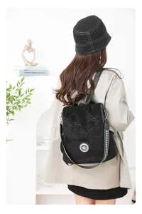 Detailed view of stylish black anti-theft women backpack with decorative metal buckle.