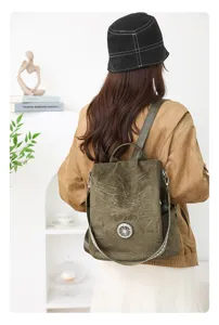 Detail view of the stylish green velvet anti-theft backpack worn by a model from behind.