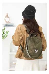 Detail shot of stylish olive green velvet backpack featuring decorative strap and metal buckle.