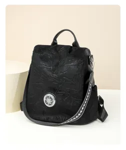 Stylish black women anti-theft backpack with metal ornament and patterned straps for travel.