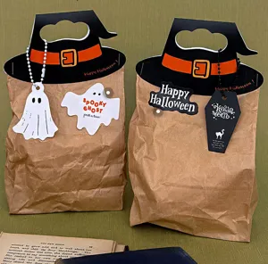 Halloween witch hat kraft paper gift bags with ghost tags for festive party decor packaging.