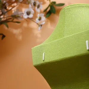 Dettaglio espositore per gioielli in tessuto verde, porta collana in lino per negozi.