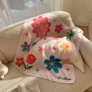 Detailopname van de kleurrijke bloemige roze sjaal, met de gladde zijdezachte textuur getoond.