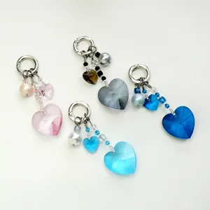 Vue détaillée de joli pendentif porte-clés cœur en cristal et perle pour sac à main.