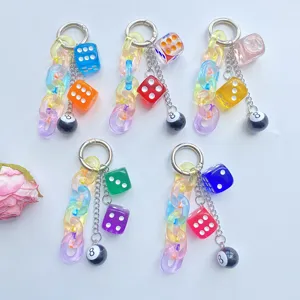 Nahaufnahme des bunten transparenten Würfel und 8-Ball Acryl Ketten Schlüsselanhängers.