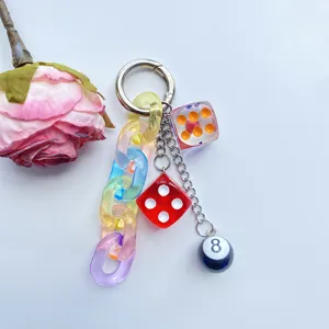 Nahaufnahme des bunten Acrylketten-Schlüsselanhängers mit niedlichen Würfeln und schwarzer 8-Kugel.