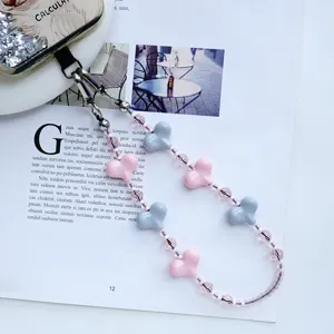 Vista detallada del dije para teléfono con cuentas de corazón rosa y gris con cristales.