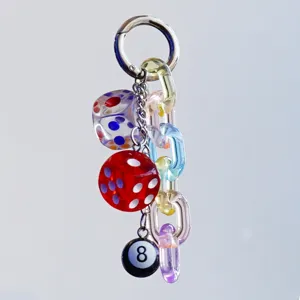 Nahaufnahme von bunten Acryl-Würfeln und schwarzem 8-Ball Schlüsselanhänger Detail.