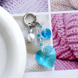 Vue détaillée du élégant porte-clés pendentif en cristal cœur bleu et perle pour sac.