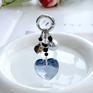 Vue détaillée du porte-clés en cristal cœur bleu scintillant avec des perles et des pendentifs.