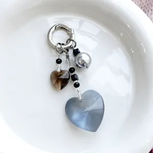 Vue de détail du charm porte-clés cristal cœur avec perles et perles noires gros plan