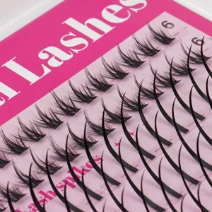 Detaillierte Nahaufnahme von DIY-Einzelbüscheln künstlicher Wimpern auf einer rosa Make-up-Schale.
