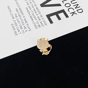 Detailed close-up of a charming cat brooch featuring a smooth cat eye stone and rhinestones.