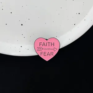 Pink heart metal brooch pin with inspirational faith over fear quote design for clothing accessories.