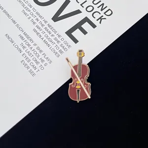 Close-up of a delicate violin enamel pin badge, artistic musical instrument accessory.