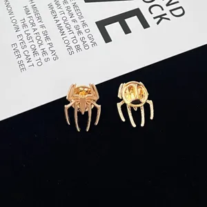 Close-up detail of the gold spider brooch pin, showcasing intricate metallic legs and texture.