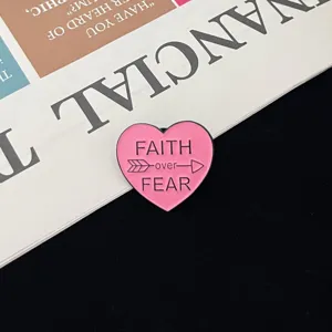 Pink heart enamel pin with inspirational faith over fear quote, metal lapel badge detail.