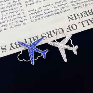 Close-up detail view of the creative airplane shaped rhinestone brooch with blue crystals and pin.