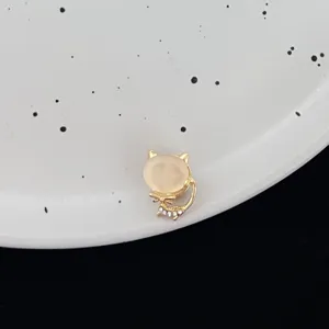 Gold-tone cat brooch featuring a smooth cat's-eye stone head and sparkling rhinestone tail details.