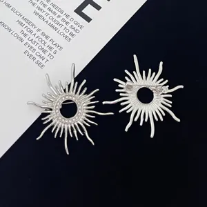 Silver sunburst brooch pin with rhinestone details, vintage baroque style coat accessory.