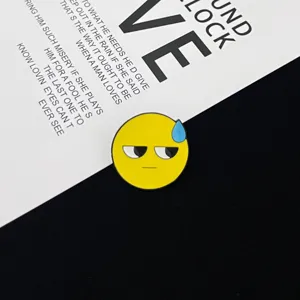 Λεπτομερές κοντινό πλάνο της χαριτωμένης κίτρινης μεταλλικής καρφίτσας σμάλτου emoji.