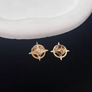 Detailed shot of gold-plated compass star brooch pin with sparkling rhinestones for men.