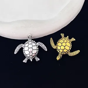 Detail view of stylish alloy turtle brooch pins in silver and gold, perfect for sweaters.