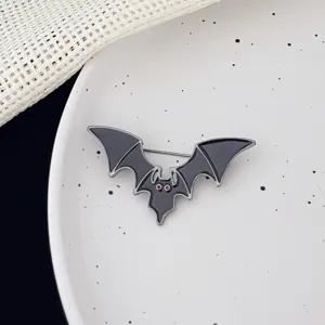 Close-up detail of Halloween devil bat enamel brooch badge with red eyes, exquisite gothic metal pin.