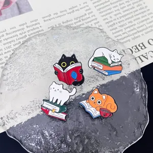 Close-up detail of cute cat metal enamel brooches reading books, stylish backpack accessories.