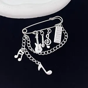 Close-up detail of the gothic punk music symbol alloy brooch featuring dangling chains and notes.