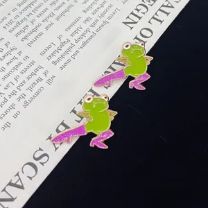 Close-up detail of funny green frog brooch wearing purple glitter high heels, creative lapel pin accessory.