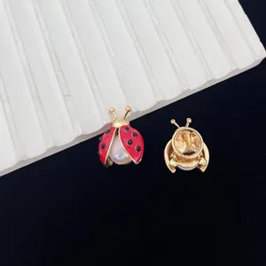 Leuke lieveheersbeestje broche van emaille met rode kleur en zwarte stippen, gedetailleerd.