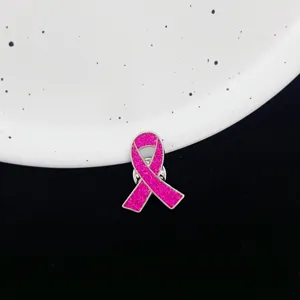 Close-up detailopname van een roze glinsterende lint broche met fijne textuur en metalen rand.