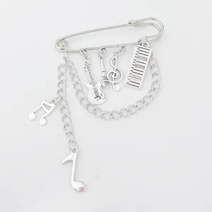 Close-up detail of gothic punk music note guitar charm safety pin brooch jewelry accessory
