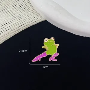Close-up of the funny green frog enamel lapel pin wearing sparkly purple high heels detail.