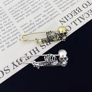 Detailopname van gotische punk skelet veiligheidsspeld broches in mooie gouden en zilveren afwerking.
