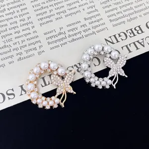 Exquisite pearl butterfly brooch detail, showing gold and silver rhinestone corsage design.