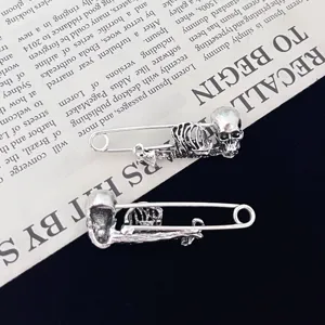 Gotische punk schedel veiligheidsspeld detail met ingewikkeld skeletontwerp en zilvermetaal.