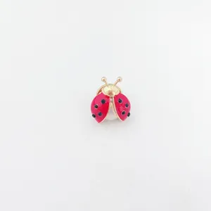 Charmante rode lieveheersbeestje broche met goudkleurig metaal en fonkelende kristallen.
