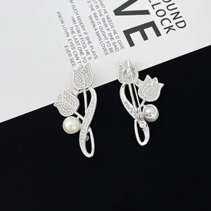 Rhinestone tulip brooch detail shot, elegant silver tone metal lapel pin with pearl accent detail.