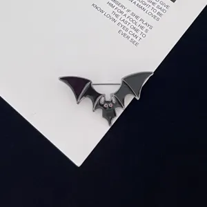 Halloween bat enamel pin detail view, spooky metal brooch with red eyes for gothic style.