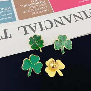 Detailed close-up shot of green clover enamel fashion brooches, versatile golden metal jewelry set.